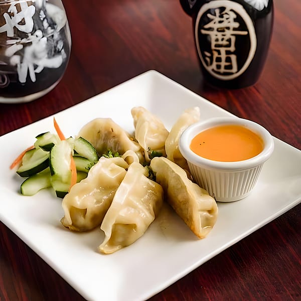 Shiki Japanese Thai Sushi Bar's gyoza dumplings with a side of cucumber salad and dipping sauce.
